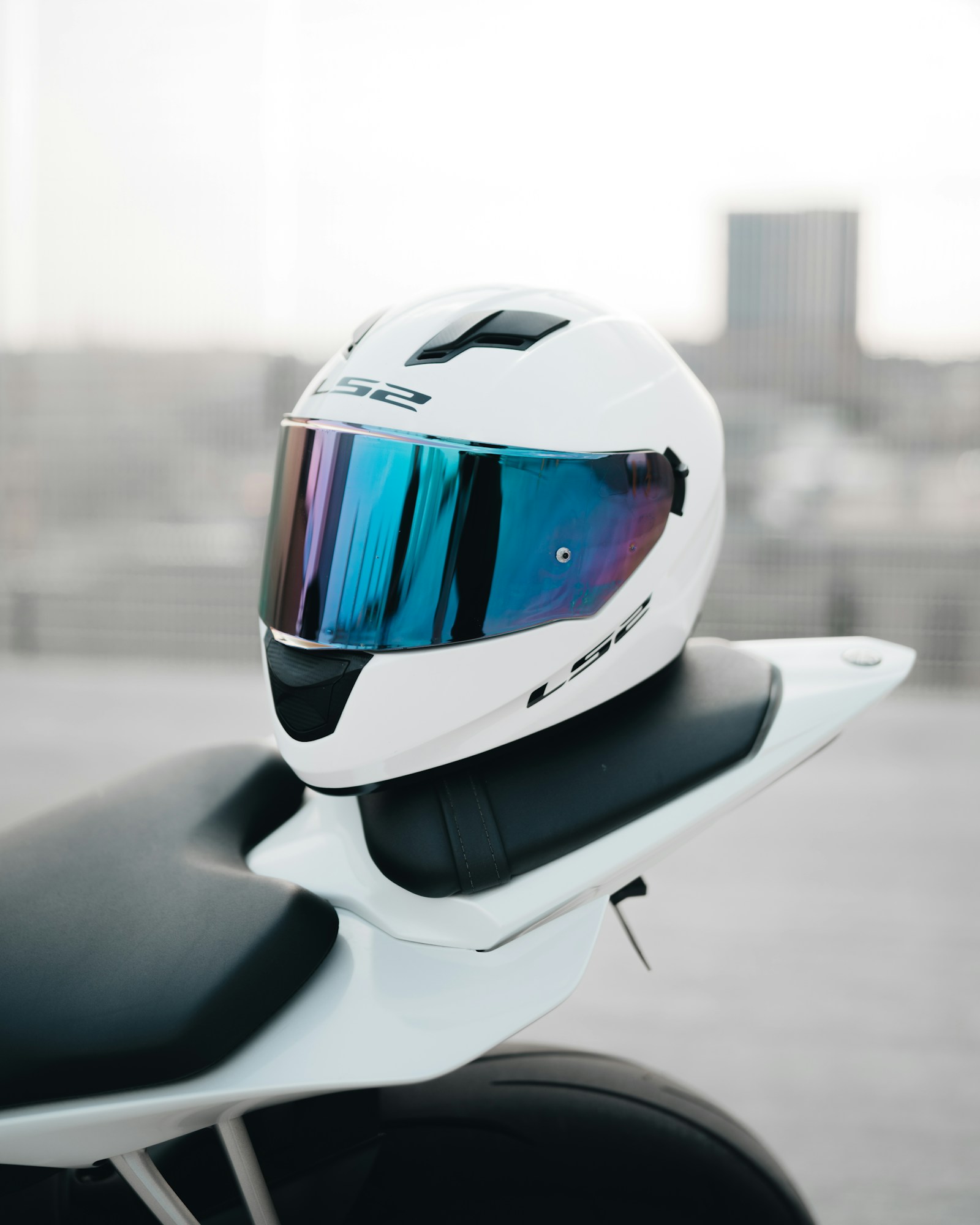 Casco integrale bianco appoggiato sulla sella