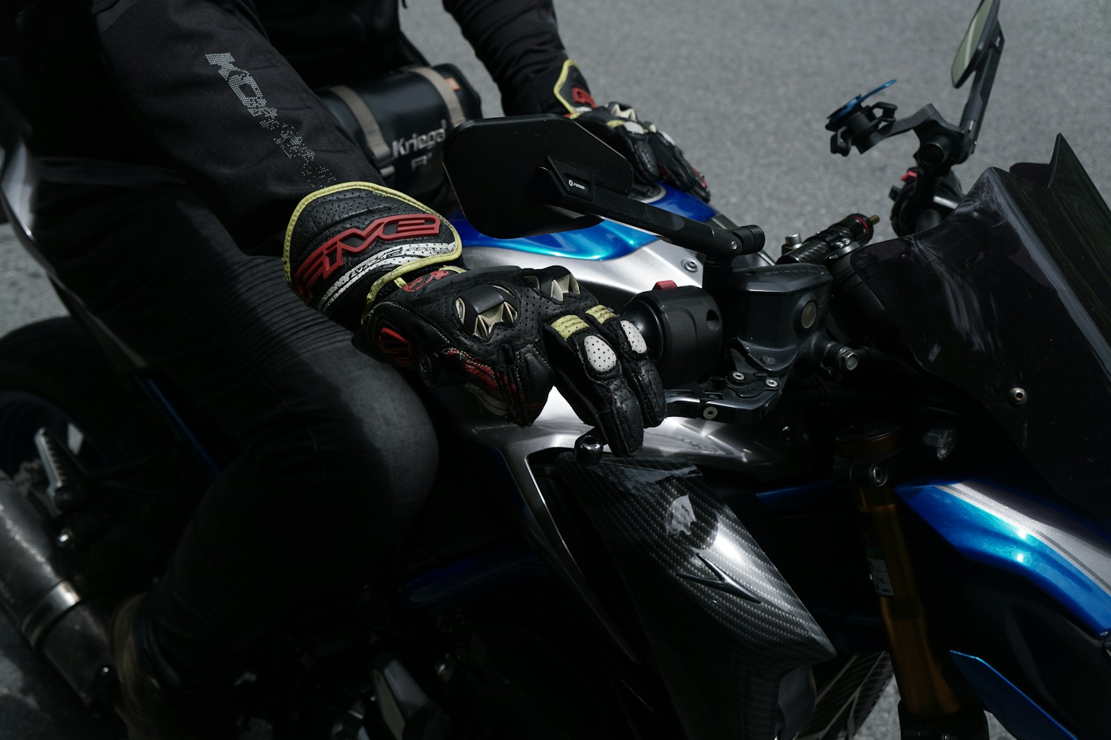 Motociclista con guanti da moto sul manubrio
