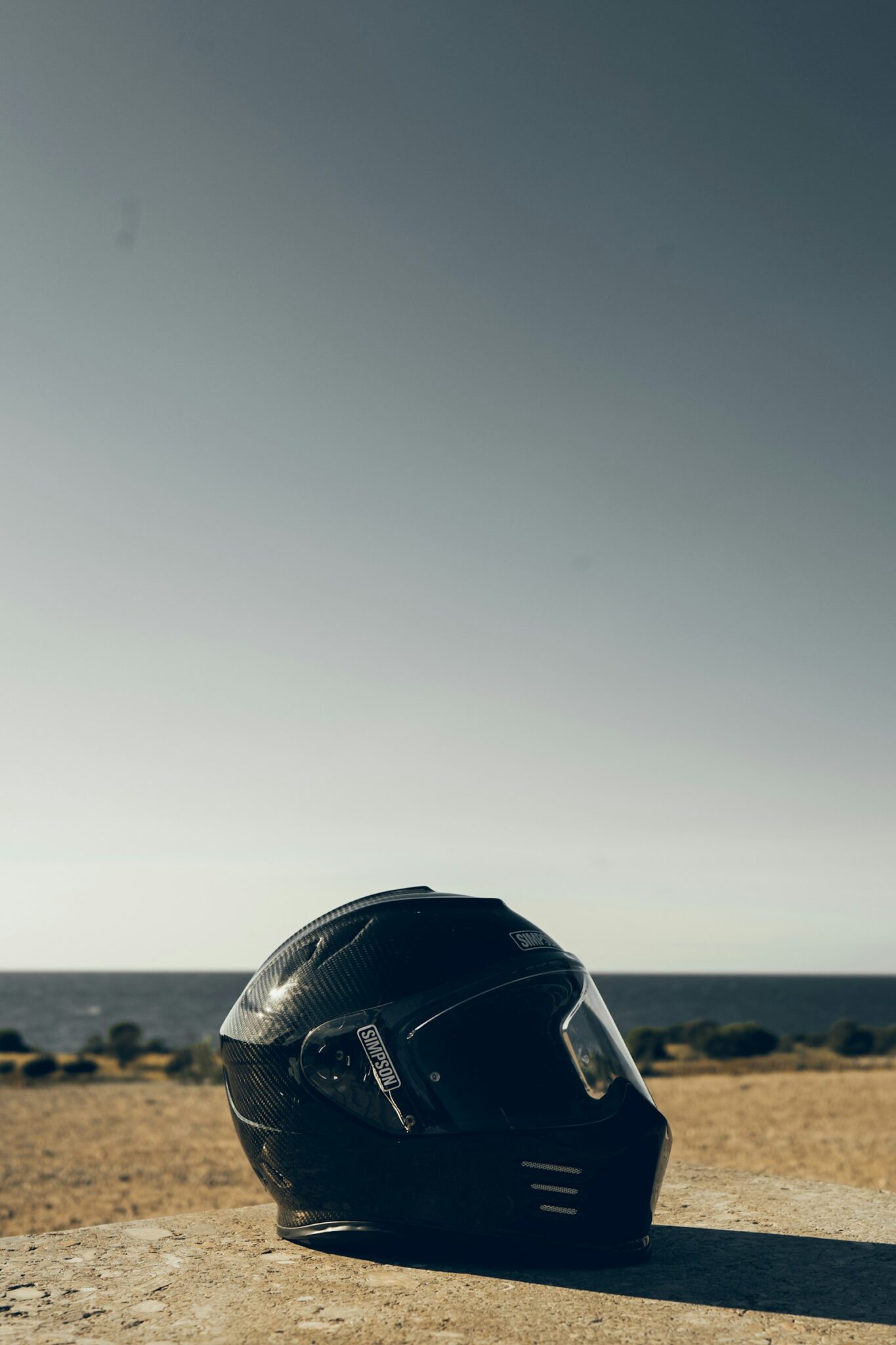 Casco moto appoggiato sulla sabbia