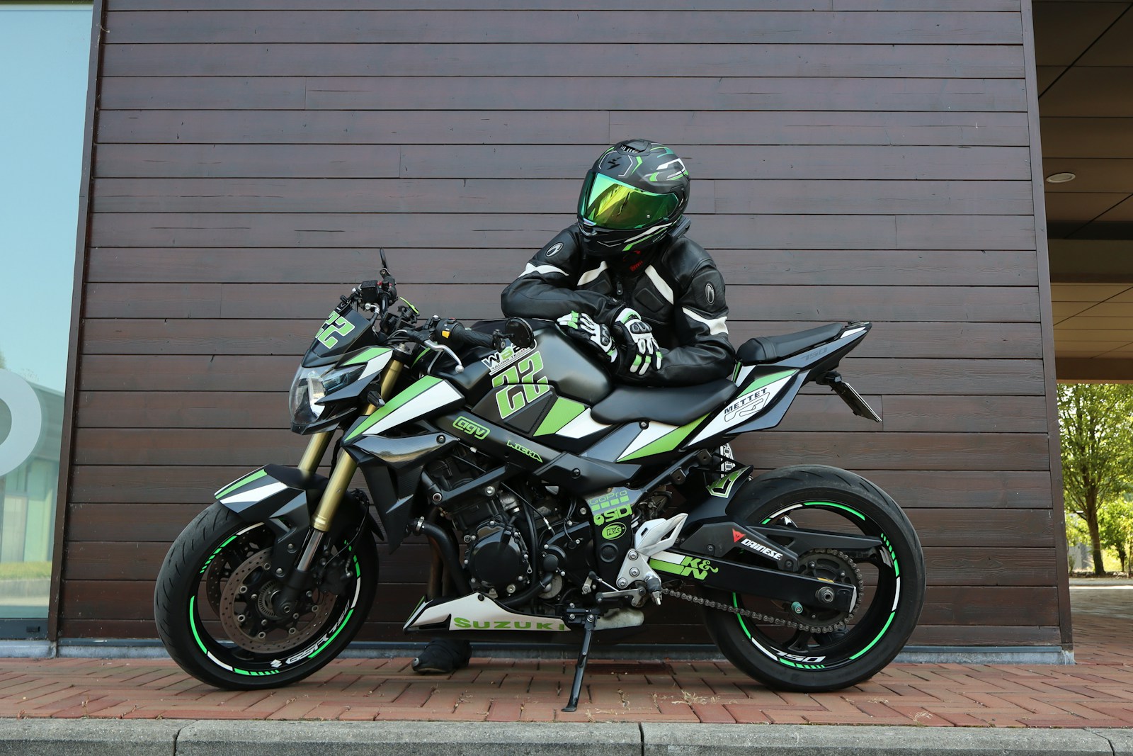 Motociclista con abbigliamento tecnico chinato sulla moto