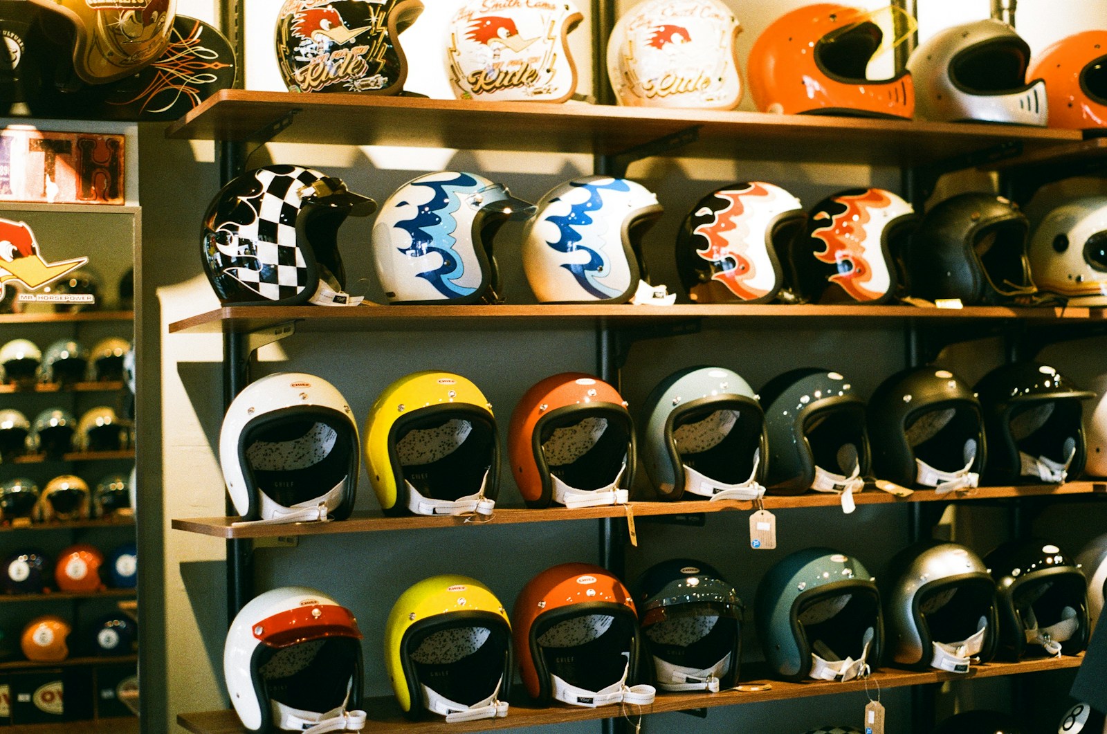 Scaffale di un negozio con caschi moto jet e integrali di vari colori