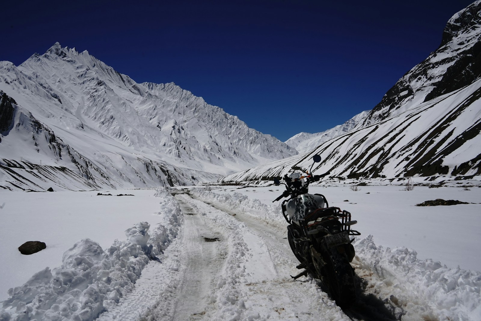 Moto ferma su una strada di montagna con neve ai lati
